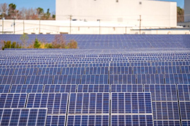 Usina fotovoltaica de solo com fileiras de módulos — imagem ilustrativa de banco (não é obra da E5)