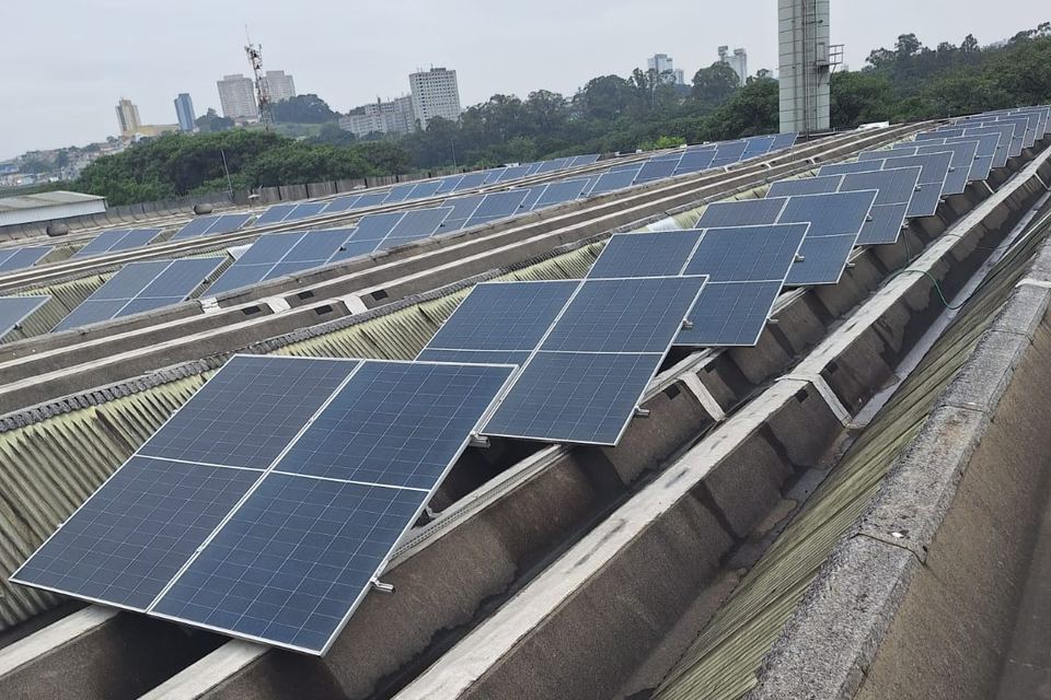 Cobertura industrial com módulos solares em planta — trabalho em campo da E5 Solar Energia