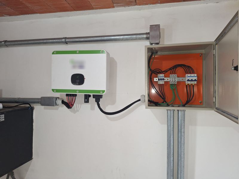 Inversor fotovoltaico e quadro CA aberto com disjuntores, fixados na parede