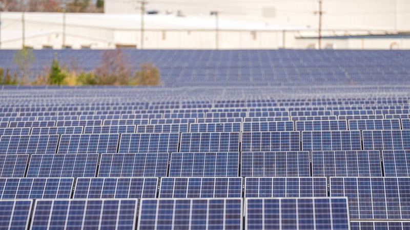 Usina fotovoltaica de solo com fileiras de módulos — imagem ilustrativa de banco (não é obra da E5)